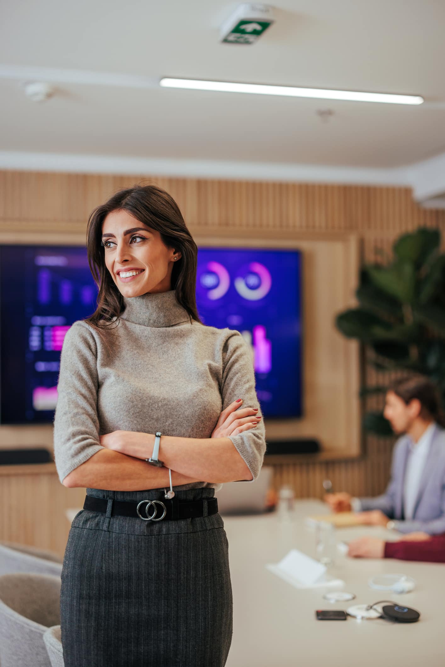 TV and Media Executive Smiles after being Recruited by Scion Staffing for the TV Industry is standing in front of a conference table